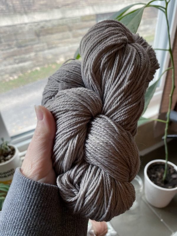 Grey yarn hand dyed with natural dye made from avocado skins and iron.